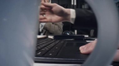 Tanımlanamayan iş adamının bilgisayarını açıp kahve fincanı alırken ve ofis masasında üzerinde belgeler olan notları okurken çekilmiş makro fotoğrafları.