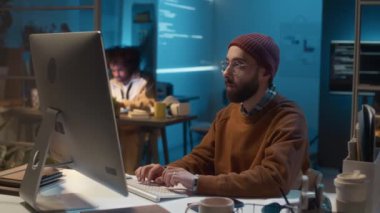BT ofisinde bilgisayar başında otururken bere takan beyaz erkek programcının portresi, sorun yaratan bağlantı sorunları.