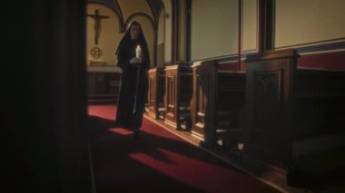 Düşük açı, Kafkas dindar bir kız kardeşin elinde mum tutarken, kilisede dua üstüne kilise sıralarında yürürken görüntüsü.