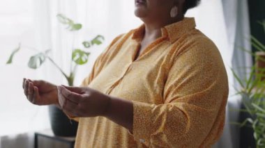 Sanal gerçeklik kulaklığı takan yaşlı siyahi bir kadın evinin penceresinin yanında oturmuş sakince oyun oynuyor.