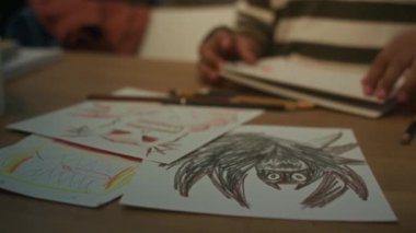 El yazısıyla tanınmayan bir çocuk tarafından çizilmiş kağıt üzerindeki canavarların resimlerini ya da kapalı mekândaki kalemleri.