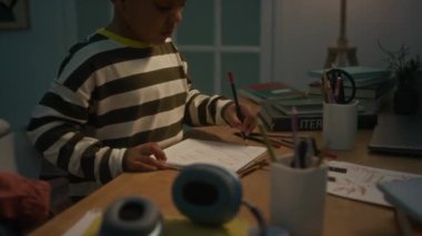 Orta boy Afro-Amerikan çocuk çizim kalemle ev masasında.