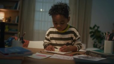 Orta boy, Afrika kökenli Amerikan kökenli şirin bir çocuk. Ev masasında kağıt üzerinde kalemle çizilmiş.