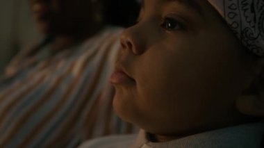 Siyah çocuk ve annesinin evdeki kanepede otururken video oyunu oynarken kamerayı eğerek çekmesini.