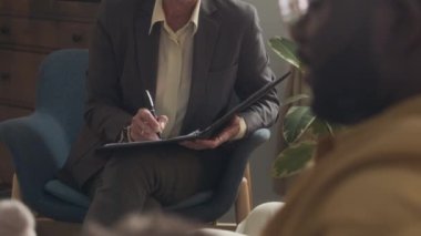 Üvey babasıyla iletişim kuran kadın sosyal hizmet görevlisinin, çocuğuyla otururken ve oyuncak tutarken çekilen görüntüsü.