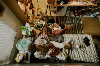 İki öğrencinin yurt odasında boş vakit geçirip konuşarak gitar çalma ve kodlama becerilerini geliştirdikleri en iyi manzara.