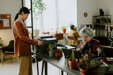 Kafkasyalı meslektaşı modern bilişim şirketinde kod hatası ararken genç Asyalı kadın belgeleri basıyor.