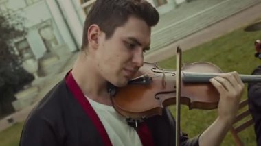 Genç, açık hava konserinde orkestrayla birlikte hızlı klasik melodi çalan kemancıdan esinlenmiştir.