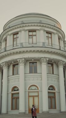 Dikey eğim, kadın müzisyenin tarihi binanın önündeki basamaklarda durup canlı performans sırasında çello çalmasını gösteriyor.