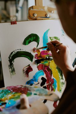 Tuvale soyut resim çizen tanınmayan erkek ressamın dikey yakın çekimi, boşluğu kopyala