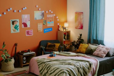 Modern gençlerin yatak odası, rahat yatak odaları, posterler ve turuncu duvarlı ışıklar, fotokopi çekimleri yok.