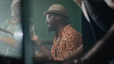 Müzik stüdyosundaki prova sırasında gülümseyen, konuşan ve gülen üç Afrikalı Amerikalı caz müzisyeni.