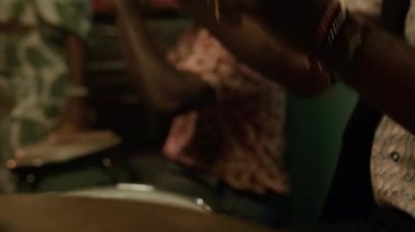 Afrikalı Amerikalı bateristin bar performansı sırasında çalmayı bitirmesini ve grup arkadaşlarıyla konuşmasını yakından izleyin, arka planda bayan müzisyen