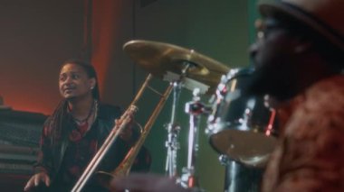Erkek tromboncu ve orkestra arkadaşının bar konserinde konga çaldığı sahne.