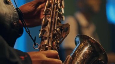 Caz konserinde orkestrayla saksafon çalan tanınmayan siyahi adamın ellerine yakından bakın.