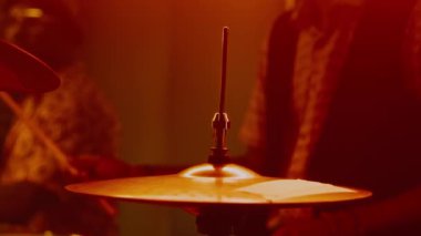 Konser sırasında pedala basan erkek davulcu, arka planda conga çalan erkek grup arkadaşı...