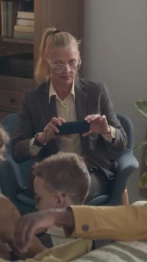 Üst düzey bir sosyal görevlinin, Afrika kökenli Amerikalı bir babanın ve iki beyaz oğlunun akıllı telefonuyla konuşurken fotoğrafını çektiği dikey bir fotoğraf.