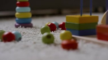 Hiçbir insan farklı şekillerde ahşap parlak oyuncaklara yakın çekim yapmaz ve halının üzerinde uzanan çocuklarda motor beceriler ve renk tanıma yeteneği geliştirmez.