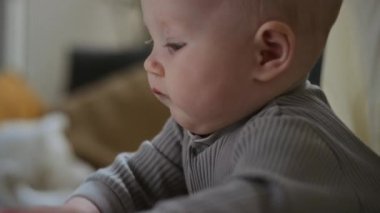 Tanımlanamayan annenin rehberliğinde dijital teknolojiyi keşfeden Kafkas bebeğinin yüzünün yakın çekimi eğitimsel oyunlarda tablete bağlanan kız ya da erkek çocukları tutmasına yardım ediyor.