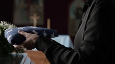 Katedral 'deki anma töreninde, tanınmayan bir kadının Amerikan bayrağını yavaşça tabut kapağına koyuşunu yakından izleyin.