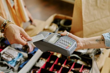 Mücevher teşhirciliği içeren perakende satış noktası üzerinden yapılan işlemi tamamlarken el ele tutuşma kartı. Elektronik ödeme yöntemi ile ödeme yapan müşterileri yakın plan görüntüle