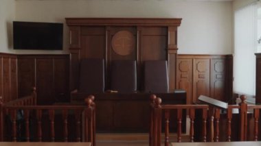 Mahkeme salonunda ahşap iç mekândan çekilen ve yargıç kürsüsü ve üç deri koltuğu olan hiç kimseyi yakınlaştırma.