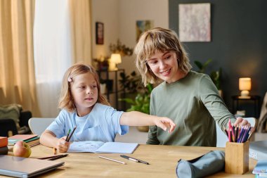 Kafkasyalı anne ve kızı birlikte kalem seçiyorlar.