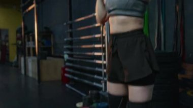 Jimnastik salonunda vücut geliştirme antrenmanı sırasında ağırlık kaldırma hareketi yapan fitness kızı.