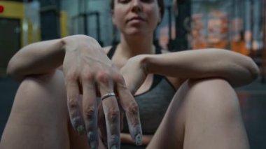 Beyaz tenli genç bir bayan sporcunun, halter kaldırdıktan sonra kameraya bakıp rahatlarken çekilen portre fotoğrafını rafa kaldırın.