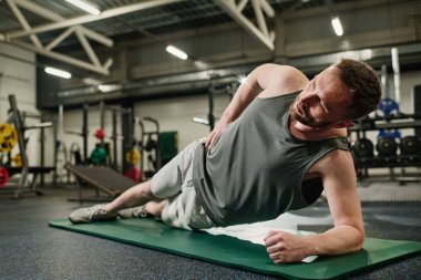 Profesyonel sporcu yeşil hasırda mükemmel yan kalas yapıyor.