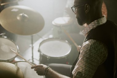 Bateri setinde ritim çalan Afrikalı Amerikalı genç müzisyenin yüksek açılı görüntüsü, boşluğu kopyala