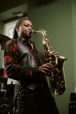 Sahnede saksafon çalan genç siyahi caz müzisyeninin dikey uzun açılı görüntüsü
