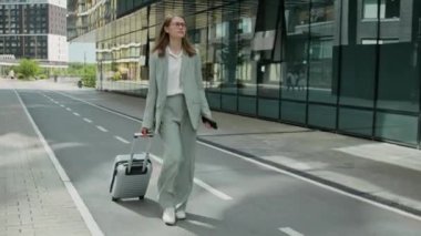 Genç bir kadın iş gezisinde. Tekerlekli bavuluyla sokakta yürüyor. Genç bir adam oteline giderken yanından geçiyor.