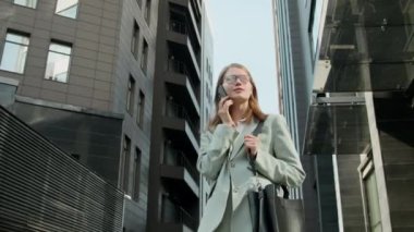 Modern ofis binasından ayrıldıktan sonra omuz çantalı genç bayan girişimcinin telefon görüşmelerini izleyelim.