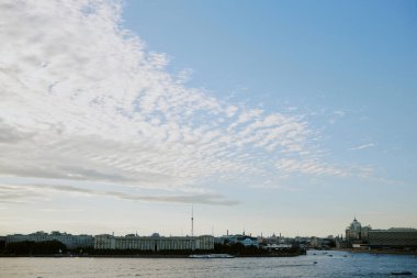 Sakin nehir boyunca manzaralı şehir manzaralı ufuk çizgisine bakan binalar sabah ışıklarıyla suya hafifçe vururken sakin atmosferi yansıtan