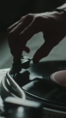 Tanımlanamayan adamın dikey yakın çekimi. Plak kaydının başında pikabın bu tonunu yerleştirmek ve playplay tuşuna basmak.