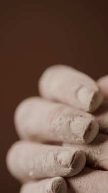 Çömlekçilik atölyesinden sonra kurumuş beyaz çamura bulanmış parmak ve tırnakların dikey detaylı çekimi.