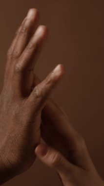 Birbirlerine nazikçe dokunan çok ırklı genç çiftin elleri hakkında dikey detaylı görüş