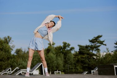 Kulaklıklı yaşlı bir kadın, trenden önce sağa doğru eğiliyor.