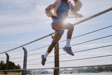 Rıhtımda koşan tanınmayan bir kadının düşük açılı çekimi.