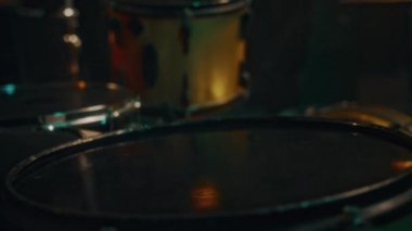 Performans sırasında veya canlı müzik etkinliğinde ilham alarak çalan tanınmayan bir davulcuyla siyahi profesyonel perküsyon setinin aşırı yakın çekimi