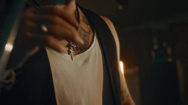 Canlı konserden önce canlı yayında prova yaparken mikrofonla sahnede duran ve grup arkadaşlarıyla konuşan vahşi, beyaz tenli erkek vokalistin orta boy yakın çekimi.