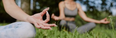 Parkta açık hava meditasyonu sırasında manikür yapan kadın elinin web sitesi afişi