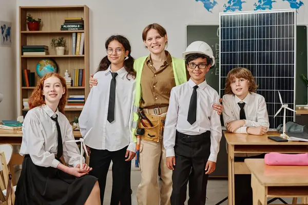 Bir grup alfa öğrencisi ve kadın mühendis okuldaki mesleki rehberlik gününde sınıfta portre için poz veriyorlar.