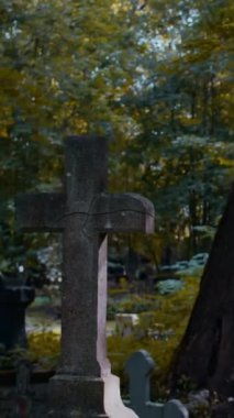 Dikey olarak, sonbahar günü arka planda altın yapraklı ağaçlarla mezarlıkta eski bir haç vurulan kimse yok.