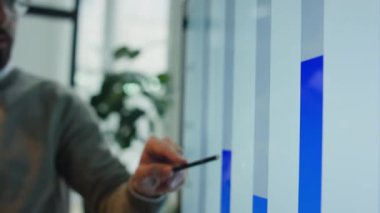 Ofis toplantısı sırasında dijital ekrandaki iş grafiklerine işaret eden mali özeti açıklayan genç erkek yöneticinin yakın plan görüntüsü