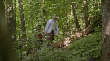 Vahşi yaz ormanlarında gezinen iki yetişkin gezginin alçak açılı görüntüsü.