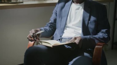 Siyahi erkek psikoterapistin terapi seansında koltukta otururken müşteriyle konuşurken görüntüsünü kaldır.