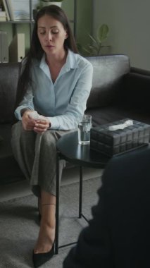 Tanımlanamayan bir erkek danışmanın omuz üstünden dikey çekimleri. Sinirli bayan müşterinin sorununu dinlemesi.