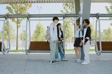 Okul gününden sonra parkta buluşan çift ırklı arkadaşlar üniforma giyip sırt çantaları taşıyorlardı.